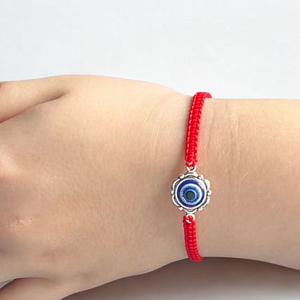 Sarkanā rokassprādze ar “ļaunās acs” simbolu – aizsardzības un veiksmes talismans. Roku darbs no Koka Brīnumiem, ideāla dāvana ar nozīmi un spēku.